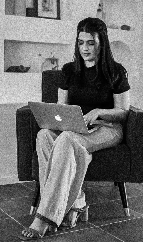 Meg working on her laptop in an armchair
